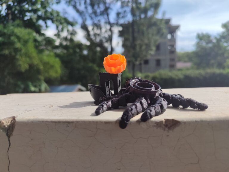 Black 3D printed boat with orange cap caught by octopus